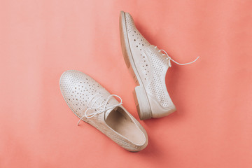 fashion beige oxford shoes on pink background.