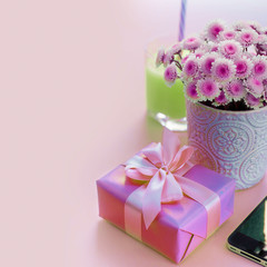 Surrealism Composition flat lay gift to a woman Modern gadget mobile phone glass cocktail perfume bouquet of flowers Preparing for the holiday surprise gift box pink background