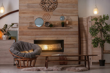 Cozy living room interior with comfortable papasan chair and decorative fireplace