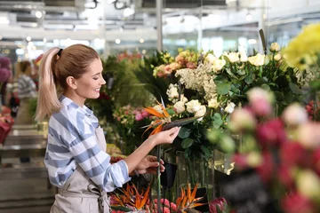 Photo sur Plexiglas Fleuriste Beautiful female florist working in flower shop