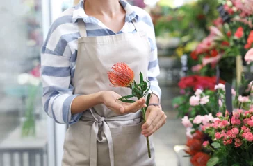 Deurstickers Bloemenwinkel Vrouwelijke bloemist die mooie bloem in winkel houdt