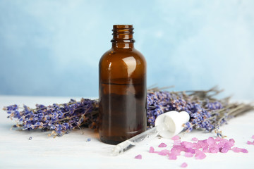Bottle with aromatic lavender oil on wooden table