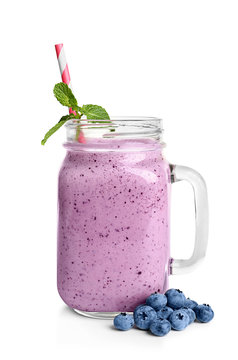Tasty blueberry smoothie in mason jar on white background