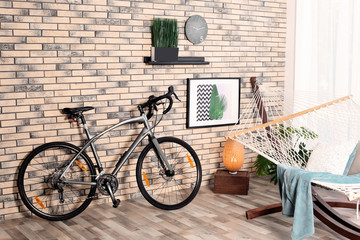 Modern bicycle and hammock in stylish room interior