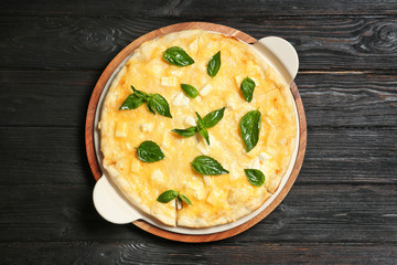 Fresh tasty homemade pizza on wooden background, top view