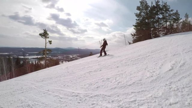 Follow Shot of a Female Snowboarder. Young woman is going down the hill on a snowbard. Follow shot