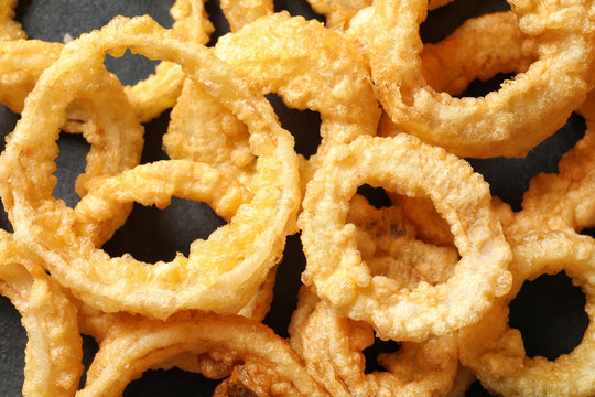 Homemade crunchy fried onion rings on table, top view