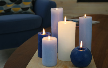 Fototapeta na wymiar Burning candles on table in living room