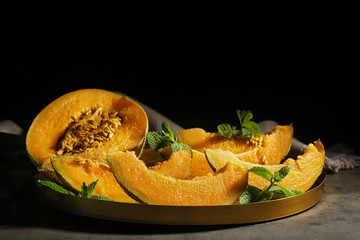 Freshly sliced ripe melon on table against black background
