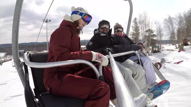 Family of Snowboarders on a Ski Resort Cable Car Taking Selfie. Nice family takes selfies while lifting on a cable car to the top of the mountain