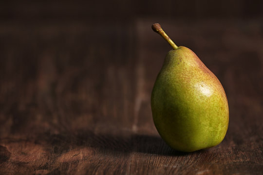 Ripe pear on wooden background. Space for text