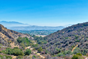 Fototapeta na wymiar Trails for hiking and biking above Southern California suburbs with houses in the distance