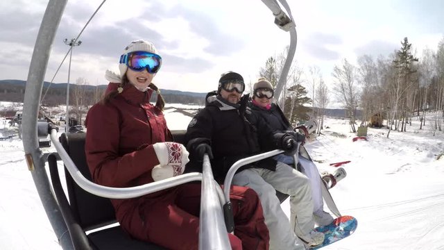 Family of Snowboarders on a Ski Resort Cable Car Taking Selfie. Nice family takes selfies while lifting on a cable car to the top of the mountain