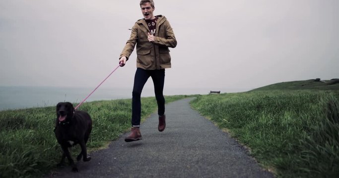 Millennial male taking pet dog on a hike