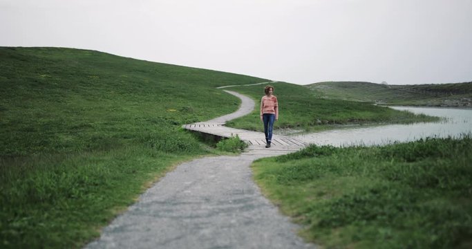 Millennial walking on a rural path towards camera