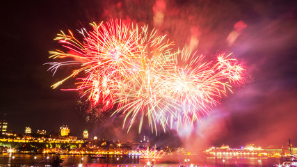 Big fireworks in front of Quebec City during a summer festival.