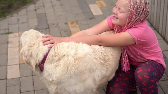 life with pets in a modern city - a girl with an unconventional appearance stroking her dog on the street