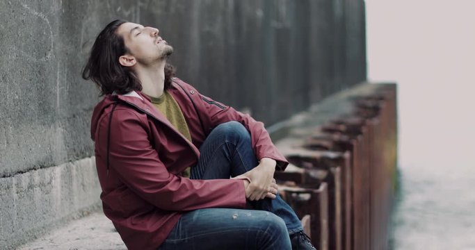 Millennial male relaxing a beach in winter