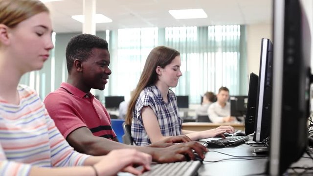 Group Of High School Students Working Together In Computer Class