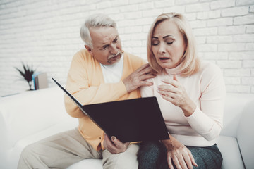 Old Man near Old Woman with Documents in Folder.