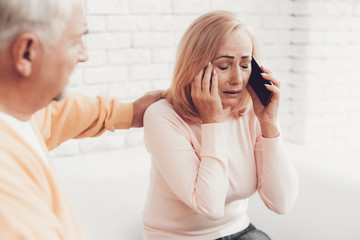 Upset Old Woman Talking on Smartphone near Old Man