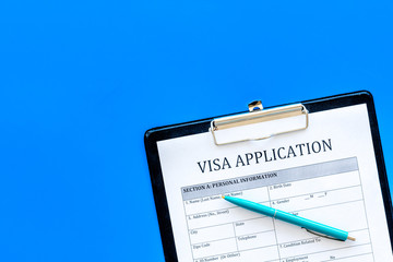 Fill visa application form. Empty blank on blue background top view copy space