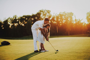 Father Playing Golf with Little Daughter on Field.