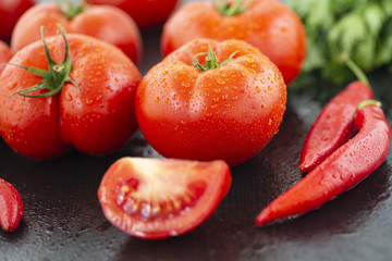 Chili tomatoes garlic and other spices for making ketchup on black background.
