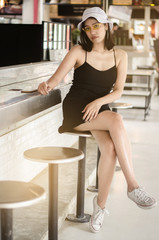 thai girl in black dress sitting at the bar