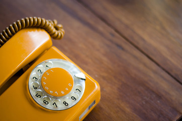 classic vintage yellow telephone on wooden table