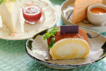 Roll cake with powder  of chocolate ,One piece in plate