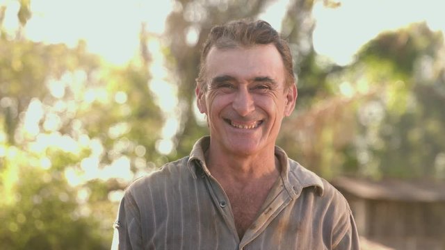 Middle aged farmer on farmland smiling looking at the camera