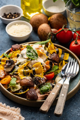 Pasta Farfalle with mushrooms, basil, tomatoes and cream sauce. Italian traditional cuisine. Mediterranean food