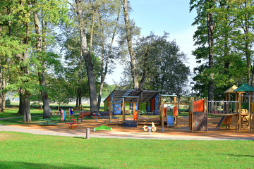 Empty colorful playground with swings and slides for children  with soft orange protective rubber...