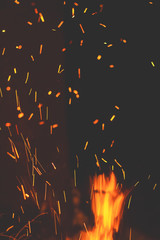 Fototapeta na wymiar Night bonfire with sparks in motion blur. Toned photo