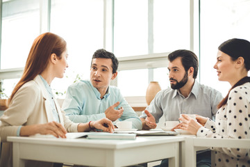 Business issues. Positive joyful people talking to each other while discussing their business