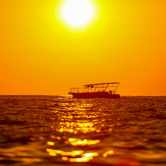 Fototapeta na wymiar Boat on the sea in the rays of sunset