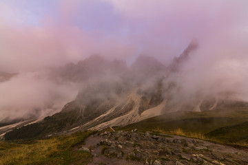 Dramatic clouds at sunset and mist in the Dolomite Mountains in autumn