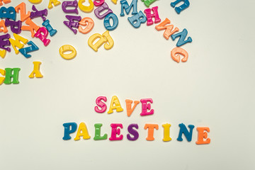 Save palestine.  Words made by colorful plastic letters