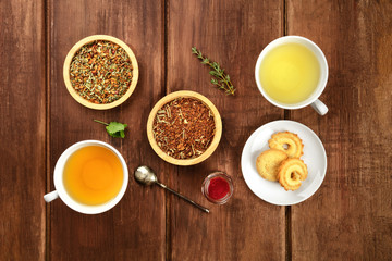 Tea tasting. Various cups of tea and leaves of loose tea with biscuits and jam