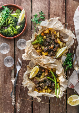 Traditional Greek kleftiko, an oven-baked lamb stew with potato, olive oil, onion, carrot, garlic and herbs, served with lemon and ouzo.