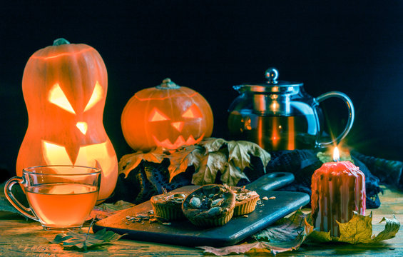 Photo of halloween pumpkins, cakes, cup of tea