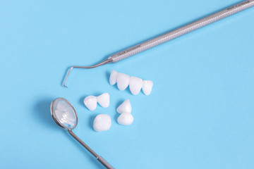 Dental tools and zircon dentures on a blue sheet - Ceramic veneers - lumineers