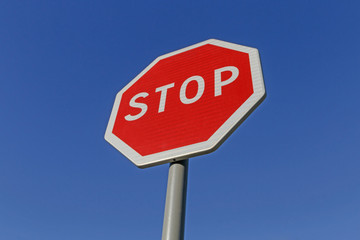 road sign stop on post against blue sky
