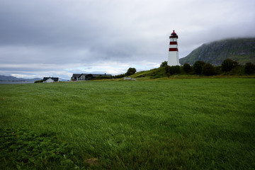 Fototapeta na wymiar Alnes Lighthouse ,old and famous building ,established in 1852 to guide fishing boats to the harbor of the fishing community of Alnes, More og Romsdal county, Norway.