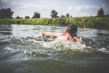The young man swimming in the river