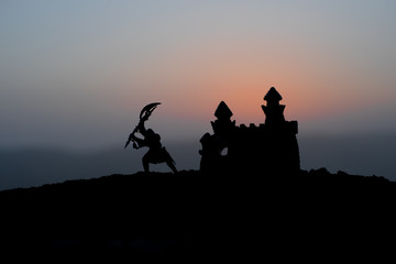 Fototapeta na wymiar Medieval battle scene on sunset. Silhouettes of fighting warriors on sunset background.