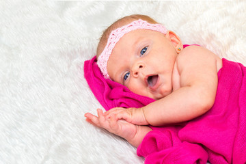 cute little girl with blue eyes in pink scarves. joyful emotions