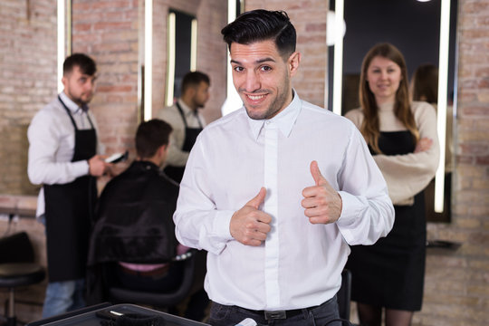 Satisfied man approving result of hairdresser work