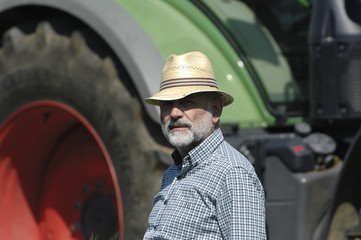 portrait of a farmer with tractor on background